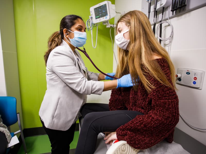 Dr. Jyothsna Akam-Venkata, a cardiologist, listens to Allie's heartbeat during an outpatient visit to the Children's Heart Center at Children's of Mississippi.