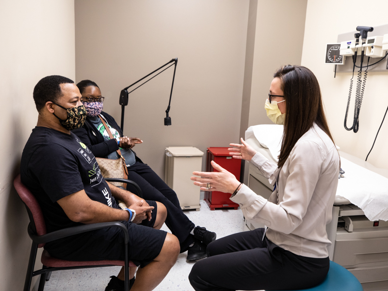 Dr. Campbell Sindel discusses COVID-19 survivor Derek Carter Sr.'s continued recovery during Carter's recent visit to the ICU Recovery Clinic. With Carter is his wife, Elizabeth McCray-Carter.