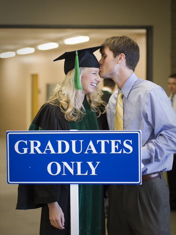 Parker Jones gives his wife Allison Jones a congratulatory kiss before she lines up to receive her Doctor of Medicine degree.