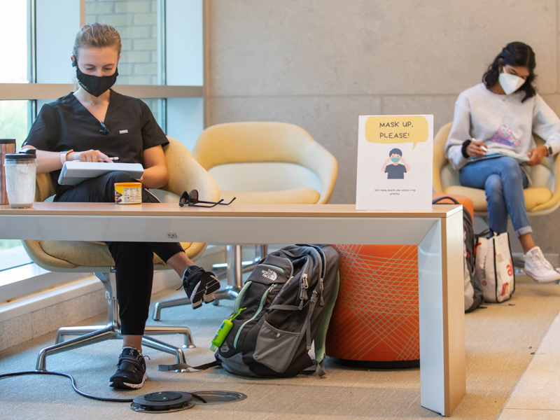 School of Medicine M1 students Karson Petit, left, and Tonya Shenoy take a study break in a 'mask up' area Wednesday.