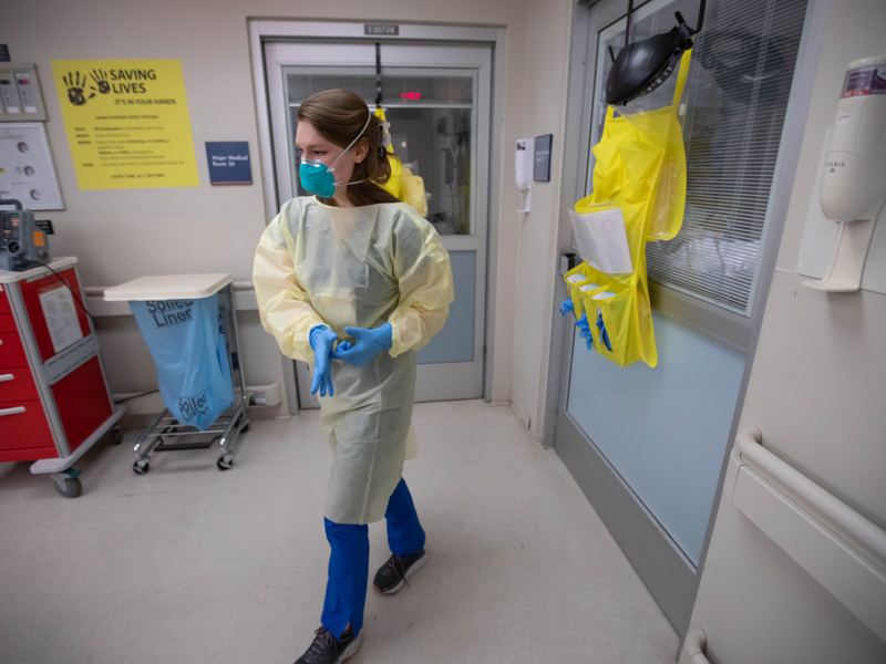 Registered nurse Maria Wilson prepares to enter the room of a COVID-positive patient in the Emergency Department. 