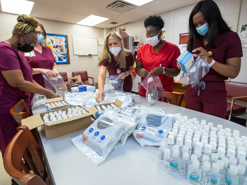 Lanier High Teen Wellness Center staff unload boxes of PPE supplies to be given out to students and teachers. From left, Patient Services Coord. Cheryl Ervin Jones, Nurse Practitioner Dr. Kayla Carr, Nurse Practitioner Valerie Morris,  Certified Medical Asst Jessica Morgan and Nurse Practitioner Ladaryl Watkins