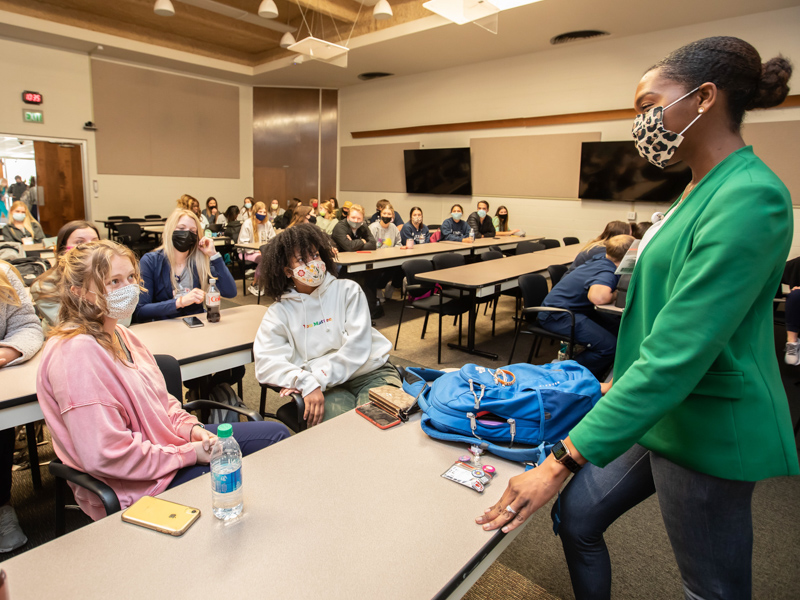 School of Nursing Instructor Andrea King, DNP, talks with nursing students after class.