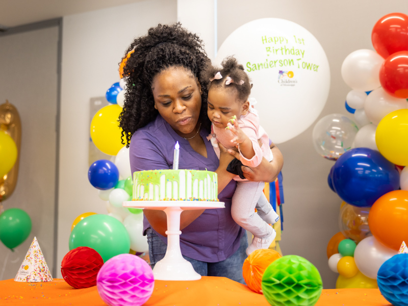 Jessica Carter of Jackson and daughter Lyndsey Lee blow out the birthday candle for the Kathy and Joe Sanderson Tower at Children's of Mississippi.