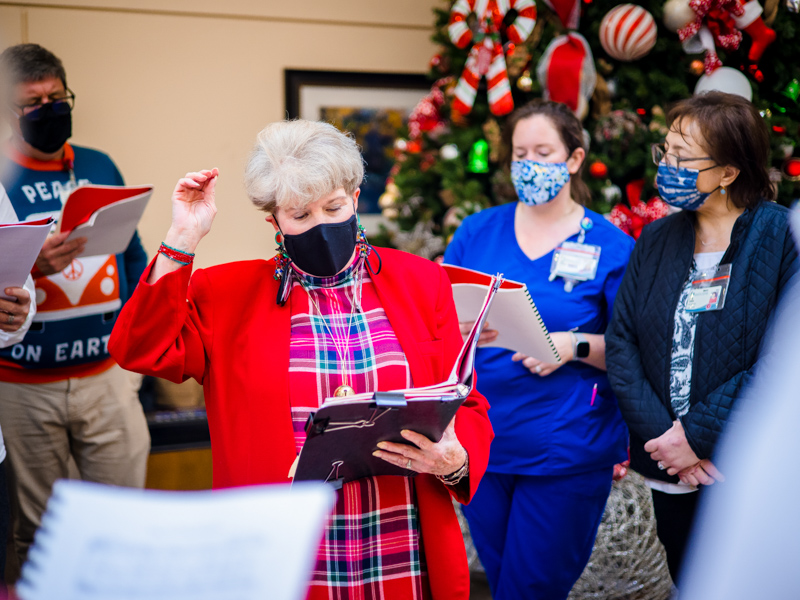 Katie Hester, center, leads the "Caroling-In-the-Belhaven-Neighborhood" group during a performance in the atrium at University Hospital at UMMC.