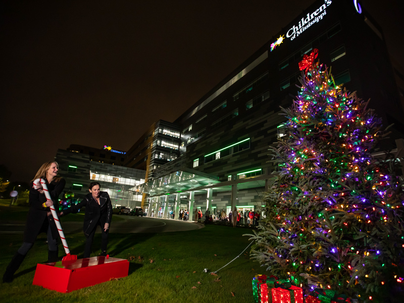 The daughters of Joe and Kathy Sanderson, from left, Emily Sanderson Whitaker and Katy Sanderson Creath pull the switch to light the Christmas tree during BankPlus presents Light-a-Light at Children's of Mississippi.