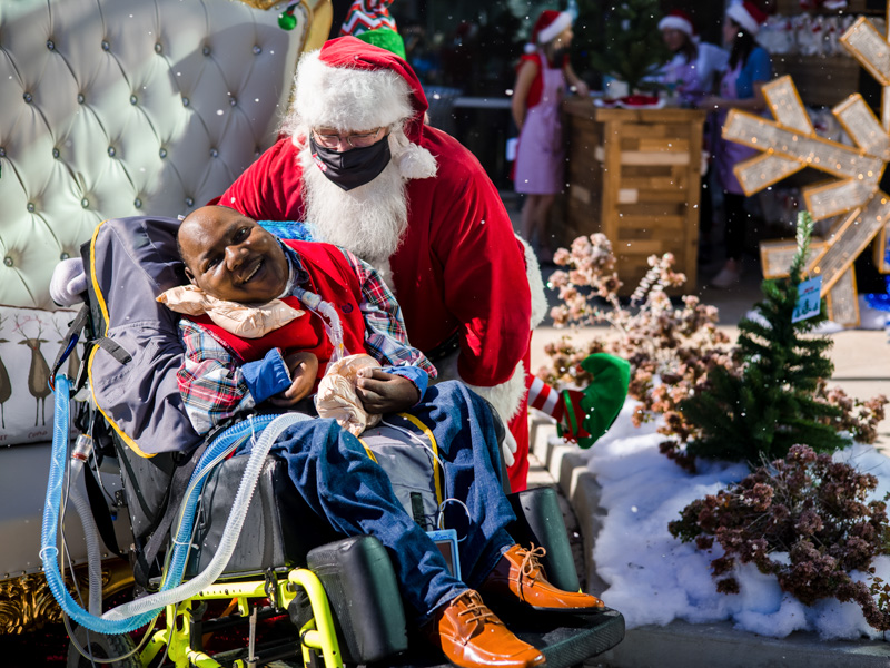 Children's of Mississippi patient William Currie smiles while visiting with Santa during BankPlus Presents Winter Wonderland.