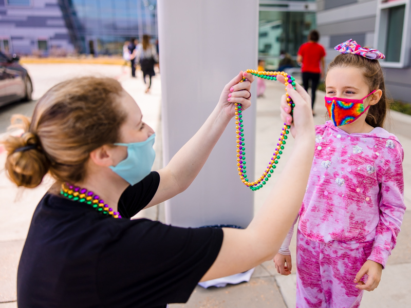 Children's of Mississippi patient Emilia Elkins of Sumrall gets Mardi Gras beads from child life specialist Madeline Wilson.