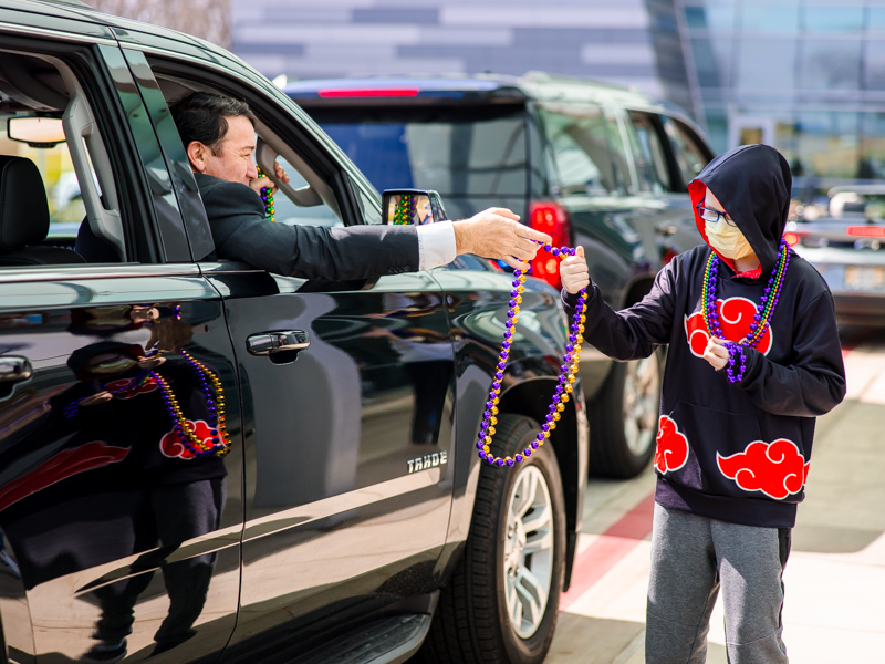 Children's of Mississippi patient Ryder Jackson of Long Beach gets beads from Mississippi Department of Public Safety Commissioner Sean Tindell during a Mardi Gras parade Thursday.