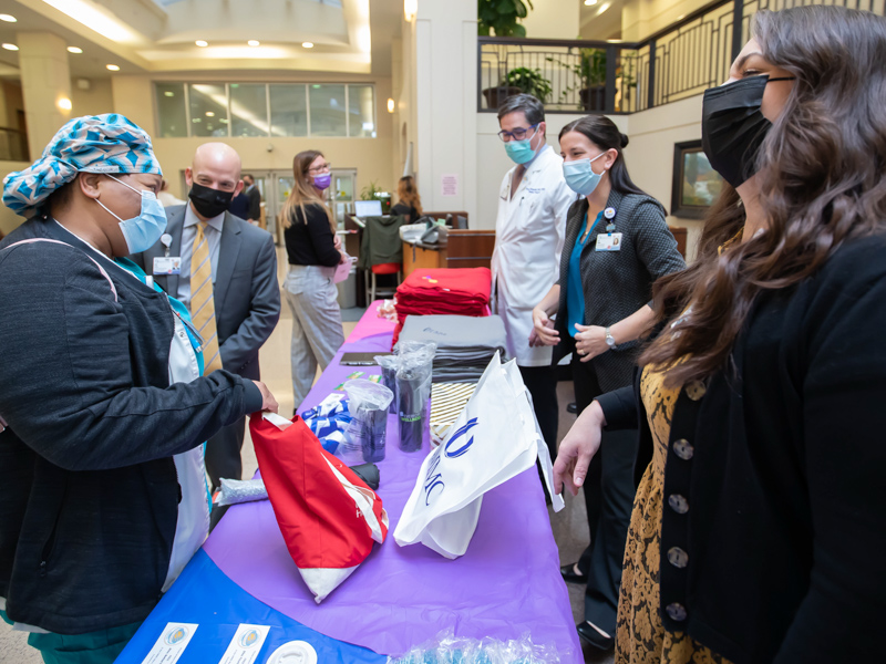 Registered Nurse Felecia Mikell visits with Dr. Alan Jones, associate vice chancellor for clinical affairs, during a Patient Safety Week prize give-away. Other hospital leaders greeting employees, include, from right, Dr. Peter Arnold, Dr. Lisa Didion and Kim Barrier.