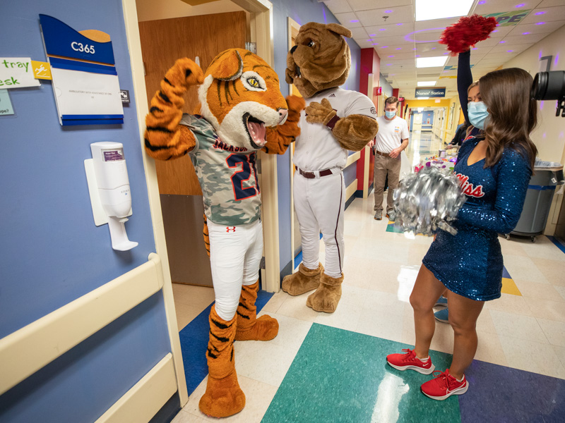 Sonny Thee Tiger and Bully pose outside of Children's of Mississippi patient rooms as Liston, left, and Granberry cheer on. Jay Ferchaud/ UMMC Communications