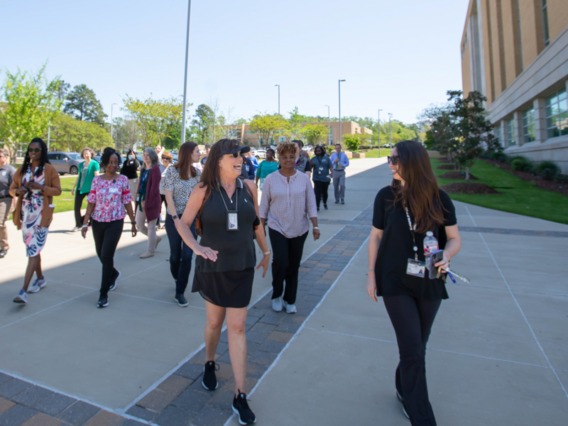 UMMC Police Chief Mary Paradis, left, and Lauren Williams, a project manager in the Office of Well-being, chat at the start of the campus National Walking Day celebration. Melanie Thortis/ UMMC Communications