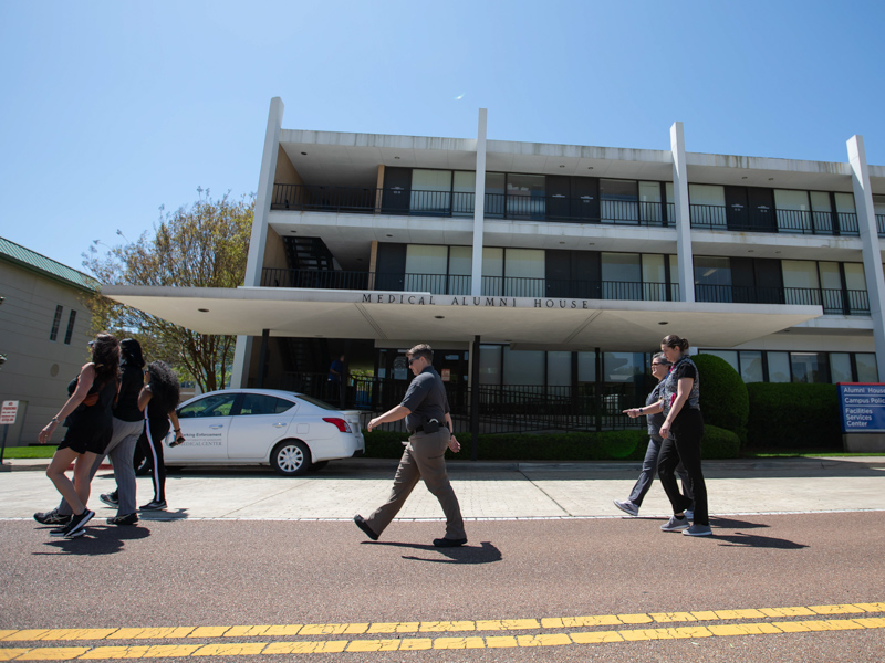 UMMC employees walk past the Alumni House during a National Walking Day celebration Friday. The walking path was nearly a mile. Melanie Thortis/ UMMC Communications