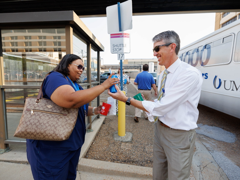 Administrative assistant Heidi Cottrell, left, receives goodies from Marc Rolph, executive director of Communications and Marketing, as she arrives for work Thursday during Emplooyee Appreciation Week. Joe Ellis/ UMMC Communications 