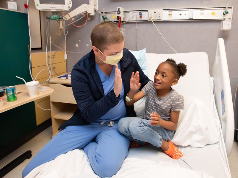 RN Lauren Burch gives patient Ma'Riyah Cooper of Hattiesburg a high five. Melanie Thortis/UMMC Photography