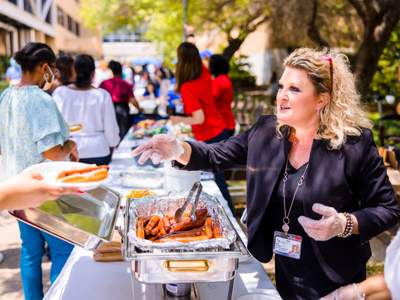 Chief Human Resources Officer Molly Brasfield scoops up a hot dog during festivities marking Employee Appreciation Week. Lindsay McMurtray/ UMMC Communications