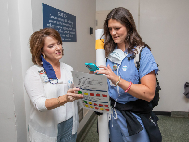 Nursing Quality & Development manager and registered nurse Susan Allbritton talks with School of Medicine student Hannah Laird about the importance of handwashing as part of World Hand Hygiene Day. Melanie Thortis/UMMC Photography