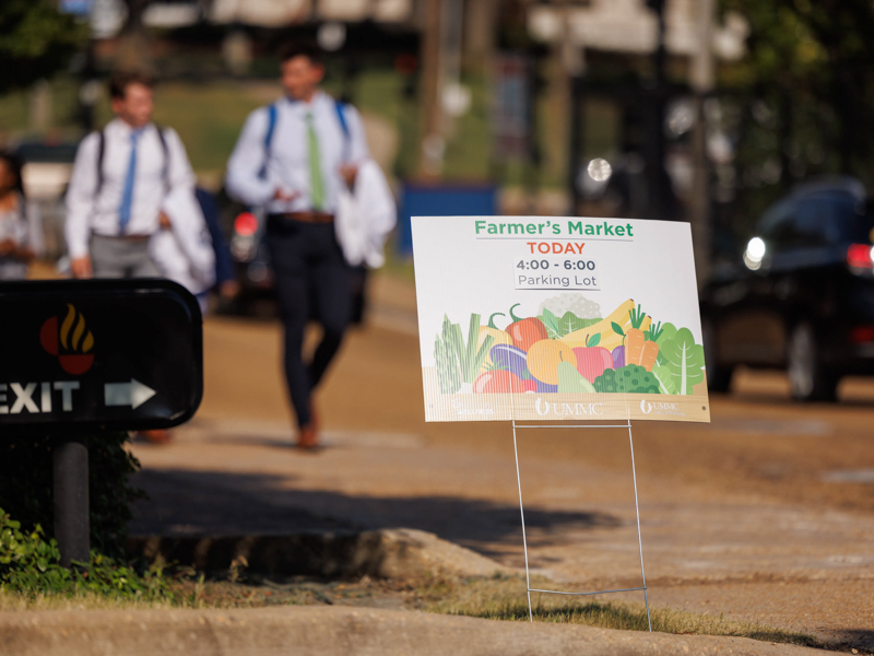 A sign beckons UMMC students and employees to Thursday afternoon's Farmers Market behind Backyard Burger. Joe Ellis/ UMMC Communications 