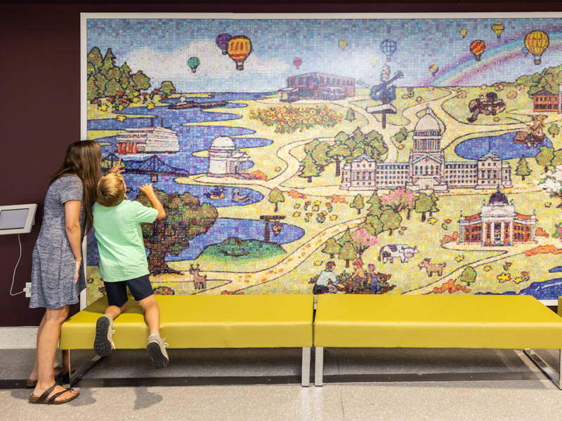 Kristel Robinson and her son, Aiden, take a closer look at the individual drawings that make up the Mississippi Mural inside the Sanderson Tower. Melanie Thortis/ UMMC Communications