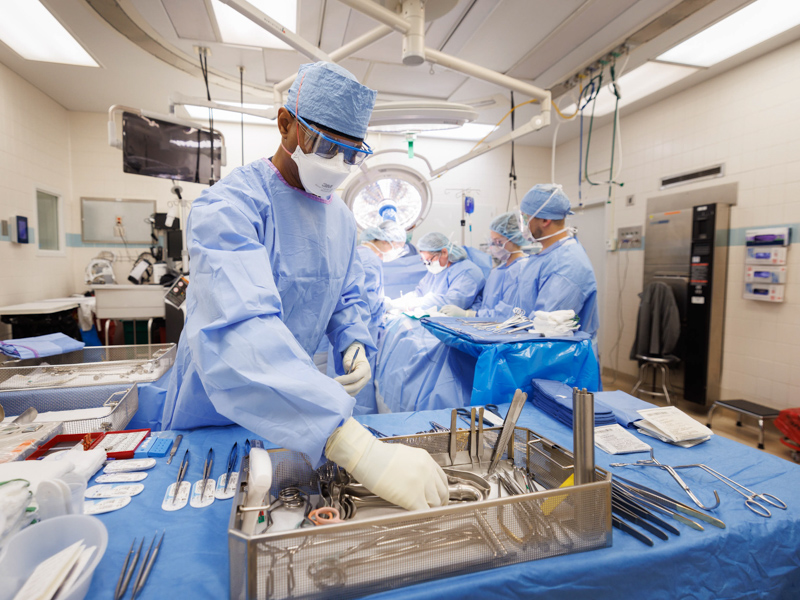 Scrub tech Anthony Poole selects sterile instruments from a tray for Dr. Felicitas Koller and other members of the transplant team to use during surgery to place Quinten Hogan's live kidney into the abdomen of Hogan's mom, Tawanna Davis. Joe Ellis/ UMMC Communications 