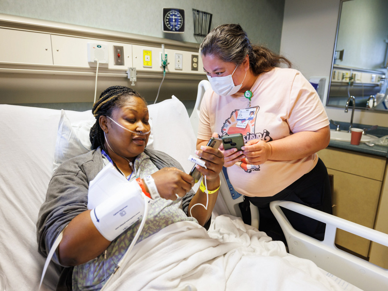Davis and her transplant surgeon, Dr. Felicitas Koller, compare cell phone pictures two days after Koller transplanted into Davis the live kidney of Davis' son, Quinten Hogan. Joe Ellis/ UMMC Communications