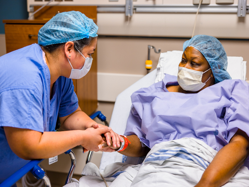 Dr. Felicitas Koller, associate professor of transplant surgery, reassures Tawanna Davis just before she's rolled to surgery. Koller transplanted into Davis' abdomen a kidney donated by Davis' son, Quinten Hogan. Lindsay McMurtray/ UMMC Communications