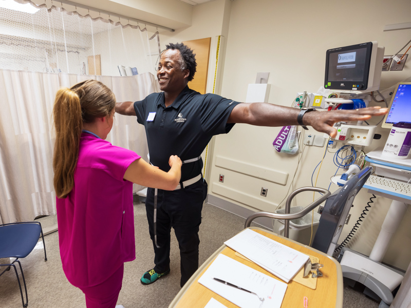 School of Nursing student Kristen Bailey measures the waist of former NFL player Stacy Siran of Nashville as part of free health evaluations Saturday at University Heart. Melanie Thortis/ UMMC Communications