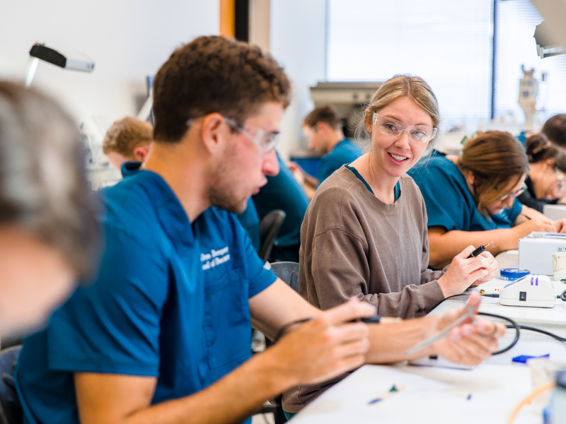 From left, first-year School of Dentistry students Dalton Dempsey, Olivia Gordon, and Bailey McPhail compete for bragging rights on who can make the best tiny work of art from melted wax.