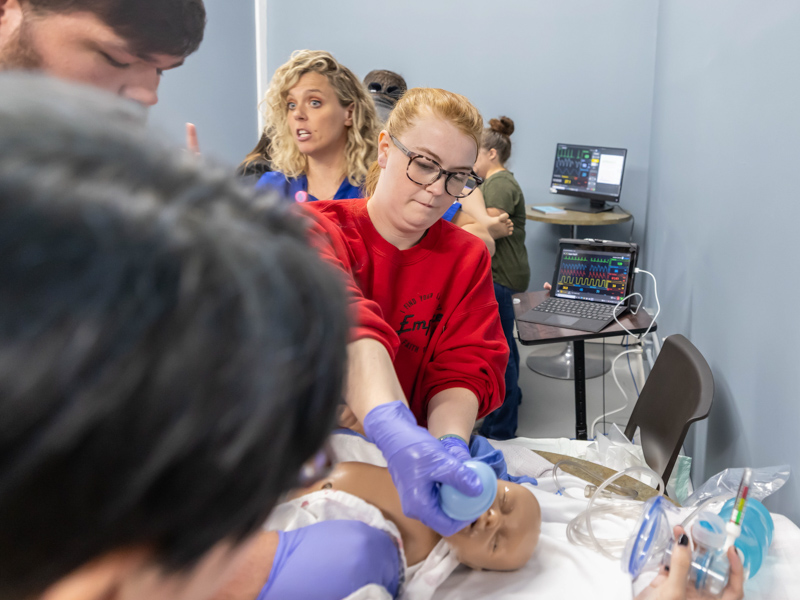 Lackey Memorial registered nurse Jordan Sawyer uses a suction bulb to clear the airway of a simulator newborn as part of STORK training. Melanie Thortis/ UMMC Communications 