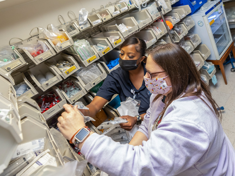 Critical care registered nurse Wendy Arinder goes over a re-stock item with supply technician Tawanna Bell in UMMC's bone marrow transplant unit. Melanie Thortis/ UMMC Communications 