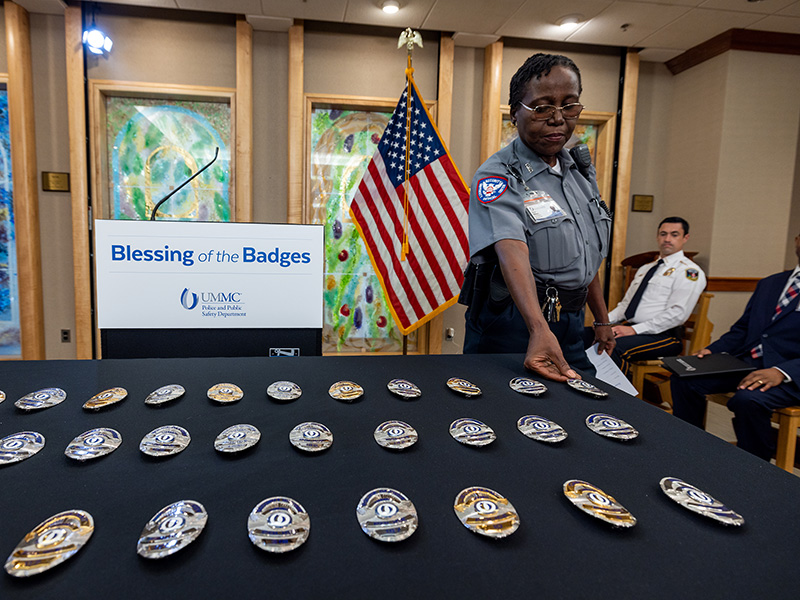 UMMC Security Officer Teresa Williams places her badge atop a table in the University Hospital chapel so that it can be blessed. Jay Ferchaud/ UMMC Communications