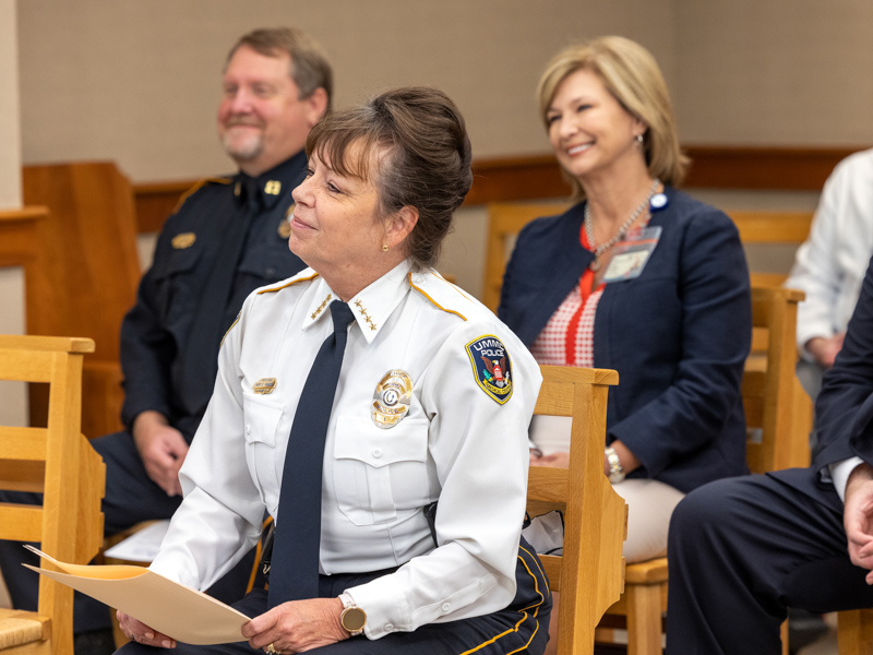 Chief Mary Paradis, second from left, listens as chaplain Mark Gilbert speaks during the Blessing of the Badges. Jay Ferchaud/ UMMC Communications 