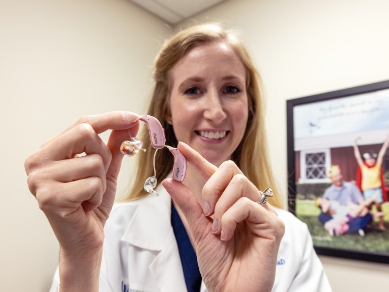 Johnson holds a hearing aid typical of those fitted for patients in UMMC Audiology. Jay Ferchaud/ UMMC Communications