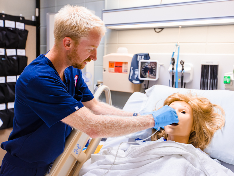 Nursing student Quinn Chandler inserts a nasogastric tube during a training exercise at the School of Nursing. Lindsay McMurtray/ UMMC Communications 