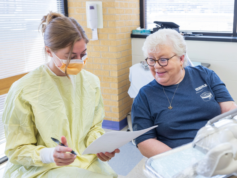 Fourth-year dental student Sara Grace Valentine explains her plan of care to patient Marlene Lyford. Melanie Thortis/ UMMC Communications