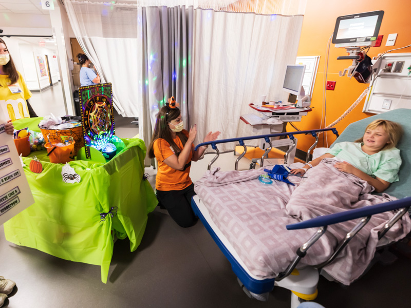 Children's of Mississippi patient Scarlett Albright of Starkville plays a Halloween game with PediaRebs members Izzabella Christian and Carly Cappleman and child life specialist Cara Williams. Melanie Thortis/ UMMC Communications 