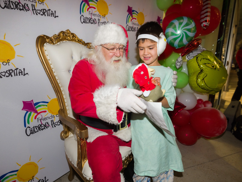 Children's of Mississippi patient Luke Alexzander Smith of Philadelphia shows a favorite toy to Santa during BankPlus Presents Light-A-Light. Joe Ellis/ UMMC Communications