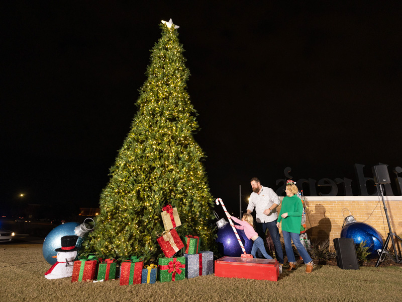 Helen Napier flips the switch to light the Children's of Mississippi Christmas tree as parents Ben and Erin Napier, stars of HGTV's "Home Town," look on. Joe Ellis/ UMMC Communications