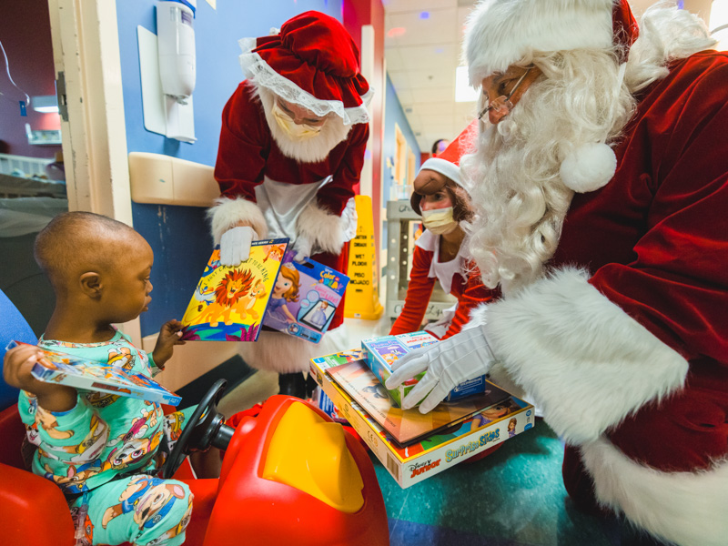 Children's of Mississippi patient Kaura McLaurin of Lumberton receives toys from Mrs. Claus, Santa, and their elf during a visit to the state's only children's hospital. Lindsay McMurtray/ UMMC Communications 
