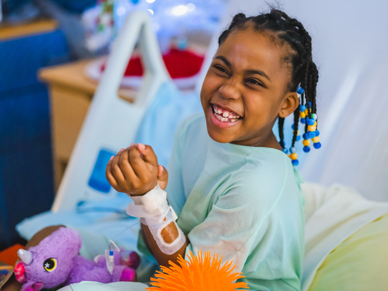 Children's of Mississippi patient Zoie Ward of Jackson smiles while receiving presents from Santa during his annual visit. Lindsay McMurtray/ UMMC Communications 