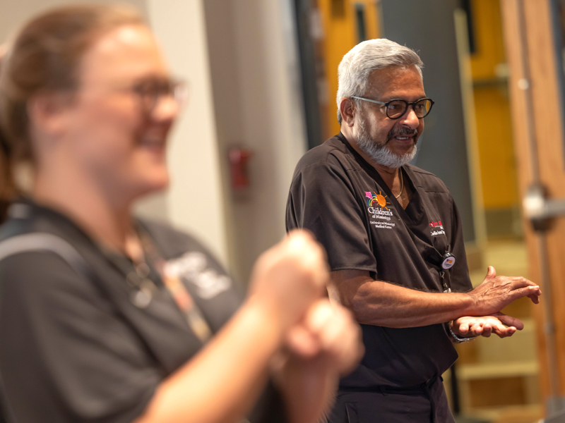 Cassidy Holland, foreground, follows the direction of Dr. Charles Gaymes in giving hands-only CPR. Melanie Thortis/ UMMC Communications