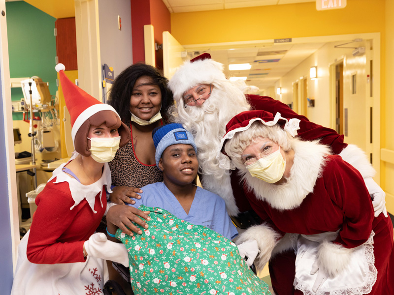 Santa, Mrs. Claus and their elf pose with Donquavius Smith of Oxford alongside mom Latasha Smith. Jay Ferchaud/ UMMC Communications 