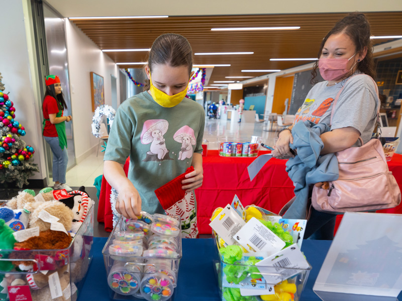 Children's of Mississippi outpatient Ayva Nichols of Pearl picks stocking stuffers during a Friends of Children's Hospital event as her mom, Jennifer Nichols, looks on. Melanie Thortis/ UMMC Communications