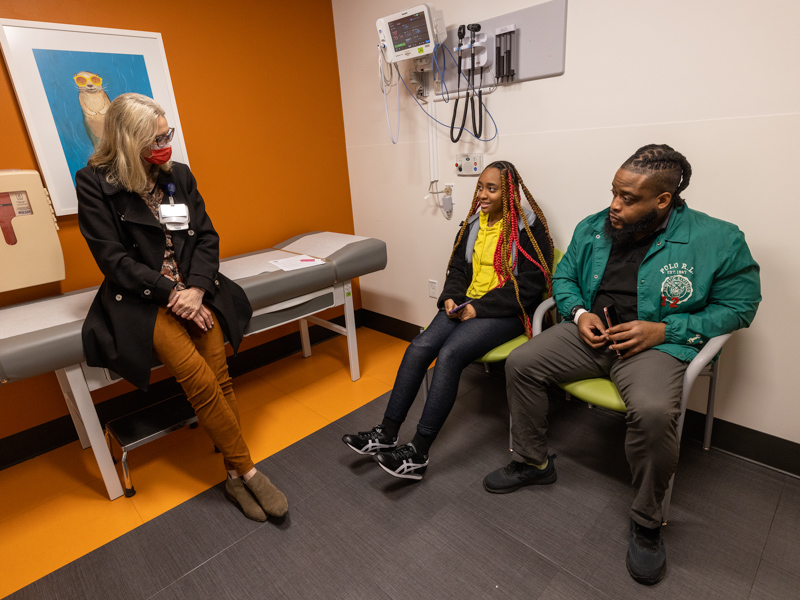 Dr. Veronica Carullo talks with patient Hevyne Hinton and her father, Jermayne Dixon, of Hattiesburg.