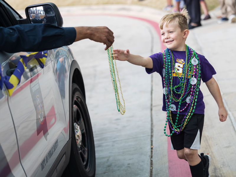 Children's of Mississippi patient Hatton Ashley of Bastrop, Louisiana, reaches for beads during the Mississippi Department of Public Safety Mardi Gras parade Tuesday. Melanie Thortis/ UMMC Communications 
