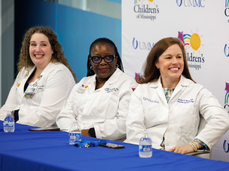 From left, Dr. Ashley Doucet, assistant professor of neonatology, Dr. Mobolaji Famuyide, chief of the Division of Newborn Medicine, and Dr. Rachael Morris, associate professor of maternal fetal medicine, smile as they listen to the Ladner family during a news conference announcing the birth of their quintuplets at UMMC.