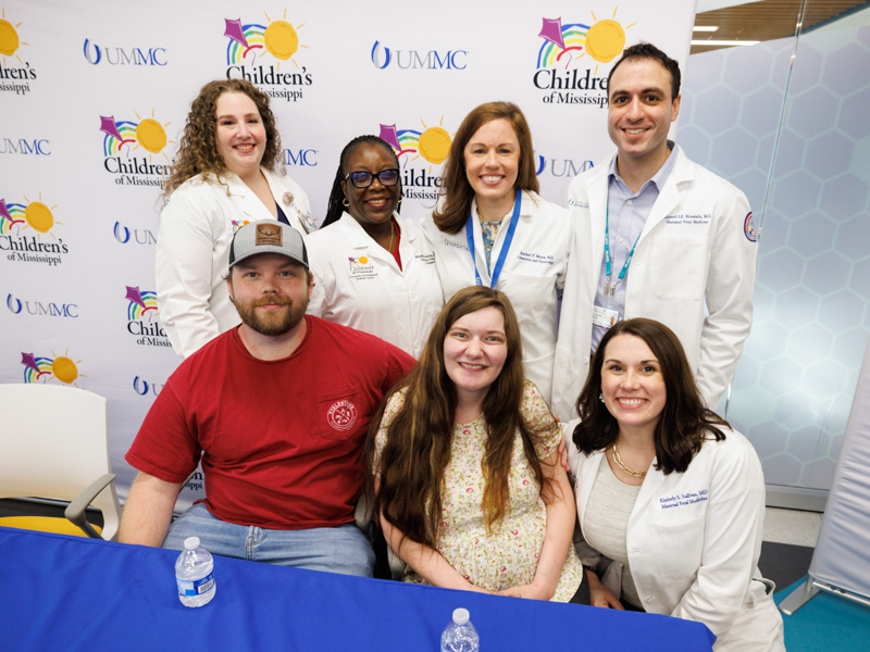 Shawn and Haylee Ladner are surrounded by a few members of their care team at UMMC and Children's of Mississippi. Standing from left are Dr. Ashley Doucet, assistant professor of neonatology; Dr. Mobolaji Famuyide, chief of the Division of Newborn Medicine; Dr. Rachael Morris, associate professor of maternal fetal medicine; and fellow Dr. Ahmed S.Z. Moustafa. Kneeling is fellow Dr. Kimberly Sullivan.