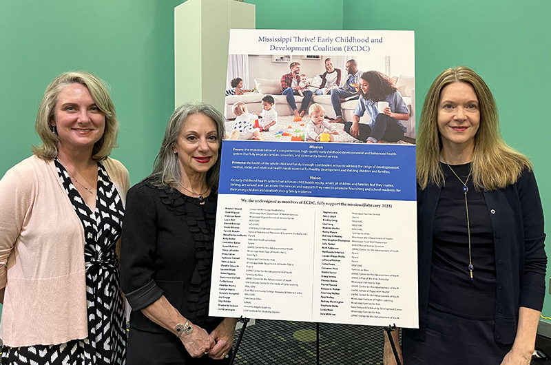 From left, Dr. Heather Hannah of Mississippi State University, Dr. Susan Buttross of UMMC, and Dr. Christina Bethell of Johns Hopkins Bloomberg School of Public Health, stand beside the coalition agreement.