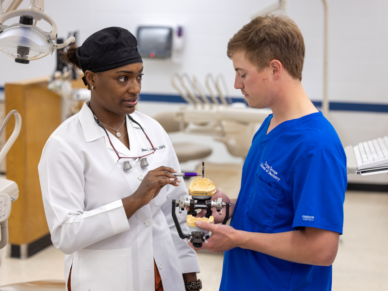 Dr. Alexa Lampkin discusses a patient's care with third-year School of Dentistry student Tripp Savage. Lampkin is the first woman dentist appointed to the Mississippi State Board of Dental Examiners.