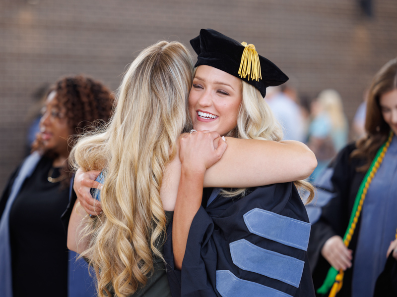 Doctor of Occupational Therapy graduates Cassidy Barnett, right and Erin Barnes share a pre-commencement hug. Joe Ellis/ UMMC Communications 